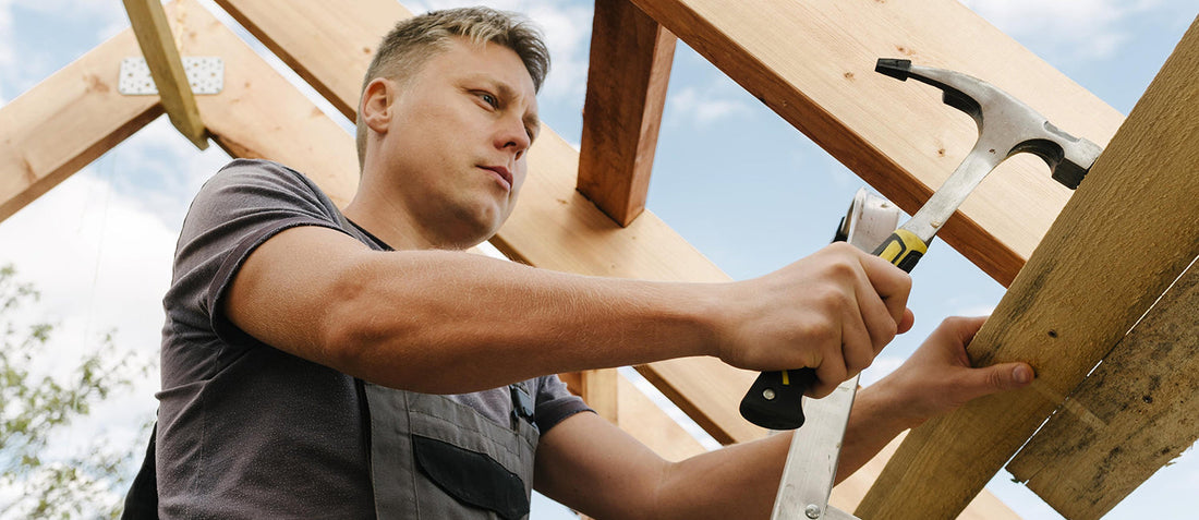 Summer cottage repair using trusted building materials; man working on outdoor roof frame