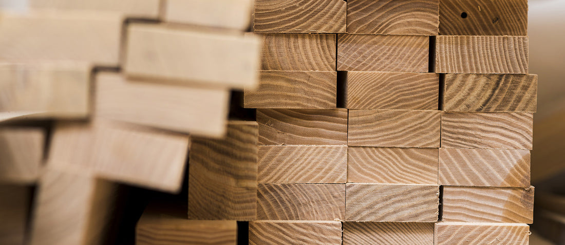 Neatly stacked lumber planks in a workshop, ready for bulk ordering or delivery.